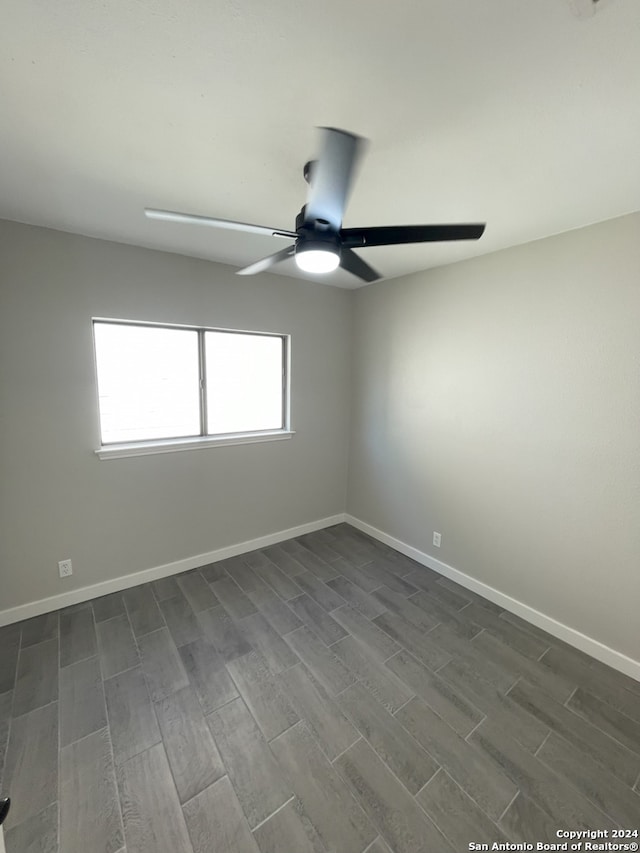 empty room with dark hardwood / wood-style floors and ceiling fan