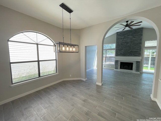 unfurnished living room featuring lofted ceiling, hardwood / wood-style floors, a fireplace, and ceiling fan