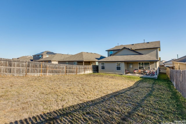 rear view of house with a patio area and a lawn