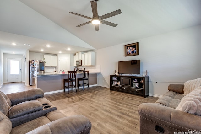 living room with ceiling fan, high vaulted ceiling, sink, and light hardwood / wood-style floors