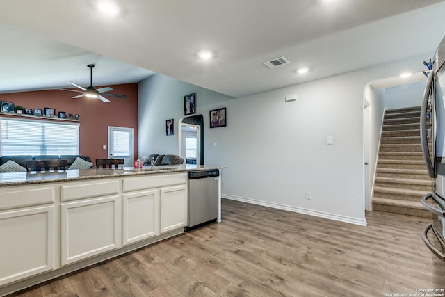 kitchen with lofted ceiling, dishwasher, light stone countertops, light hardwood / wood-style floors, and white cabinets