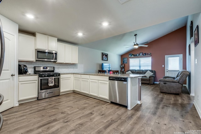 kitchen featuring stainless steel appliances, white cabinets, light wood-type flooring, and kitchen peninsula