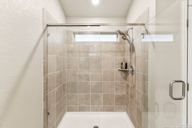 bathroom with a shower with door