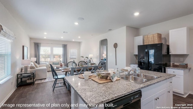 kitchen featuring sink, white cabinetry, dark hardwood / wood-style floors, black appliances, and a center island with sink