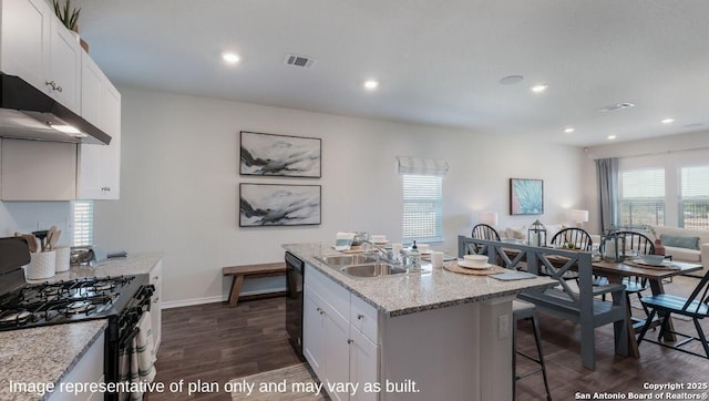 kitchen with white cabinetry, a kitchen breakfast bar, a kitchen island with sink, and black appliances