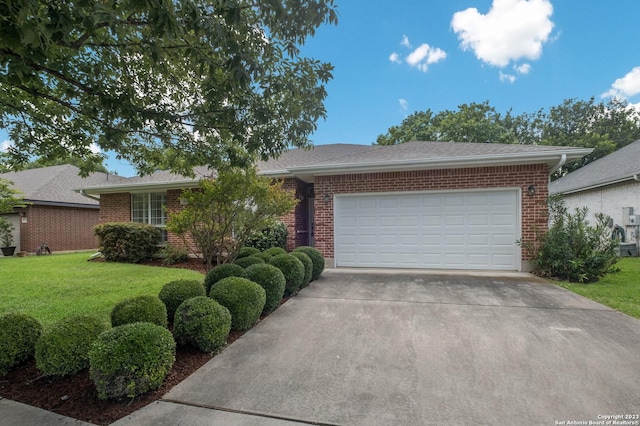 ranch-style home with a garage and a front lawn