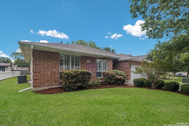 view of front of house featuring central AC, a garage, and a front yard