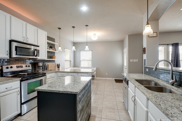 kitchen featuring white cabinetry, appliances with stainless steel finishes, a center island, and sink