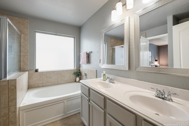 bathroom featuring tile patterned flooring, vanity, independent shower and bath, and a textured ceiling