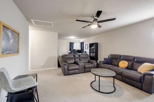 carpeted living room featuring ceiling fan and a textured ceiling