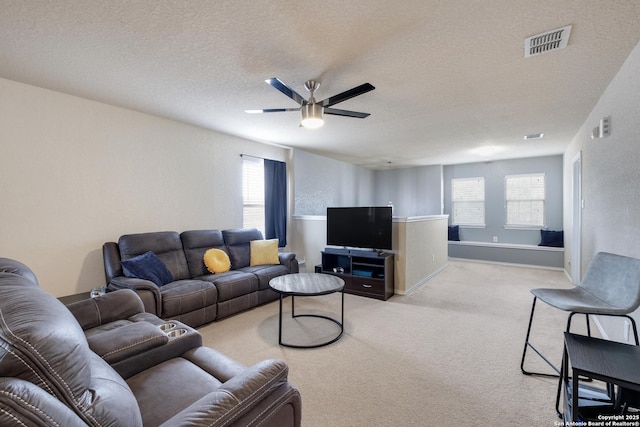 carpeted living room featuring a textured ceiling and ceiling fan