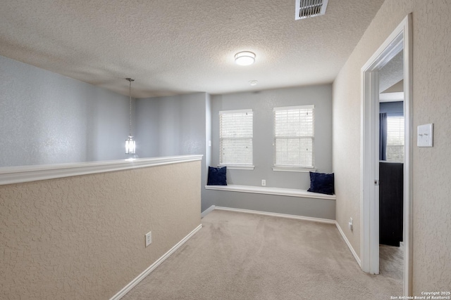 hallway featuring carpet floors and a textured ceiling