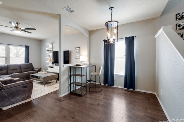 living room featuring dark hardwood / wood-style floors, a textured ceiling, and ceiling fan