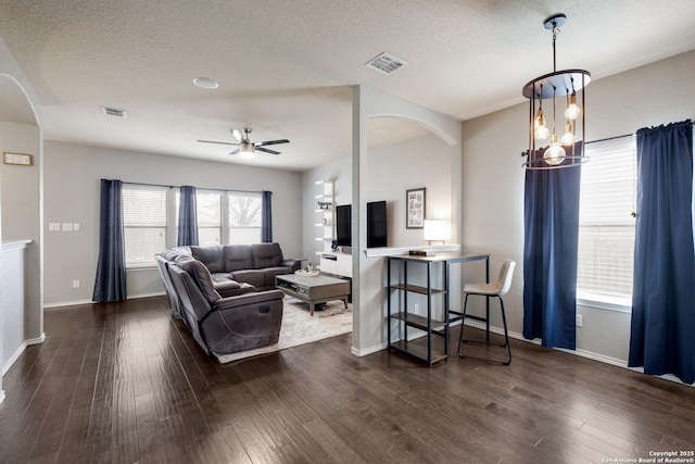 living room with ceiling fan, a textured ceiling, and dark hardwood / wood-style flooring