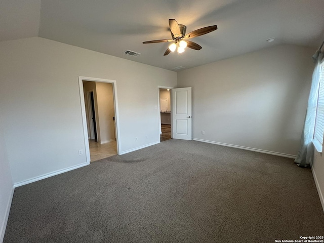 unfurnished bedroom with lofted ceiling, ceiling fan, and dark colored carpet