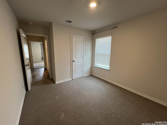 unfurnished bedroom with dark carpet