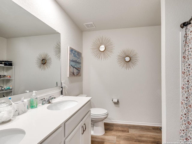 bathroom featuring vanity, hardwood / wood-style floors, and toilet