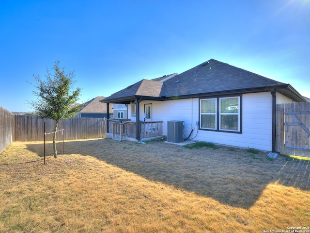 back of property with a lawn and central air condition unit