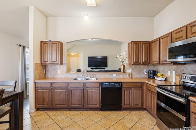 kitchen with light tile patterned flooring, appliances with stainless steel finishes, sink, and decorative backsplash