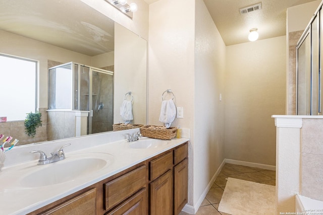 bathroom with vanity, an enclosed shower, tile patterned flooring, and a textured ceiling