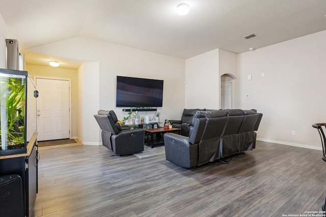 living room with dark hardwood / wood-style flooring and vaulted ceiling