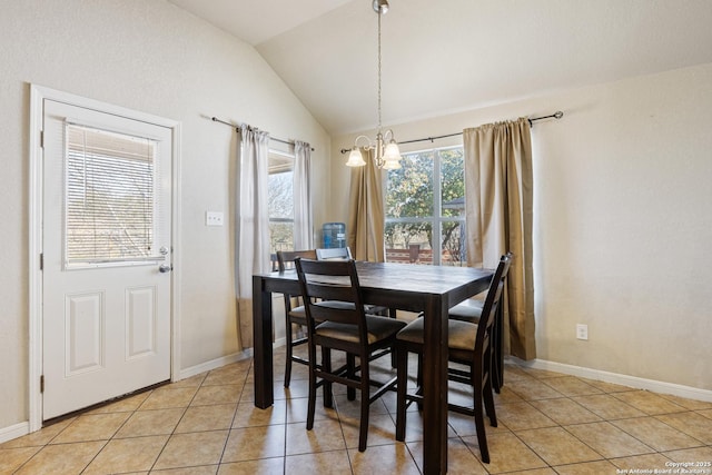 dining area with lofted ceiling, light tile patterned floors, and an inviting chandelier