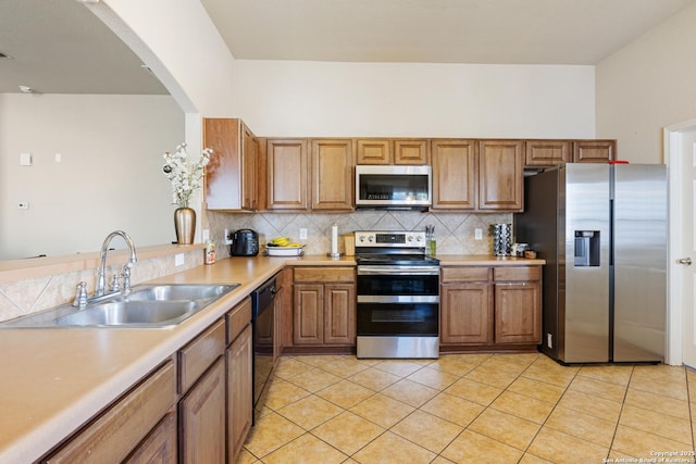 kitchen featuring stainless steel appliances, sink, light tile patterned floors, and backsplash