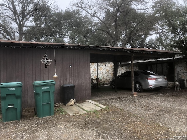 view of vehicle parking featuring driveway and a carport