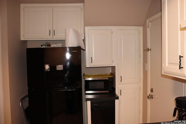 kitchen with white cabinetry and black fridge