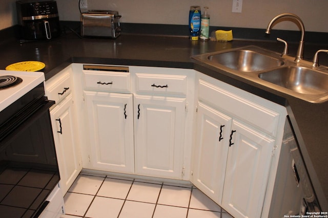 kitchen with white cabinetry, sink, light tile patterned floors, and stainless steel dishwasher