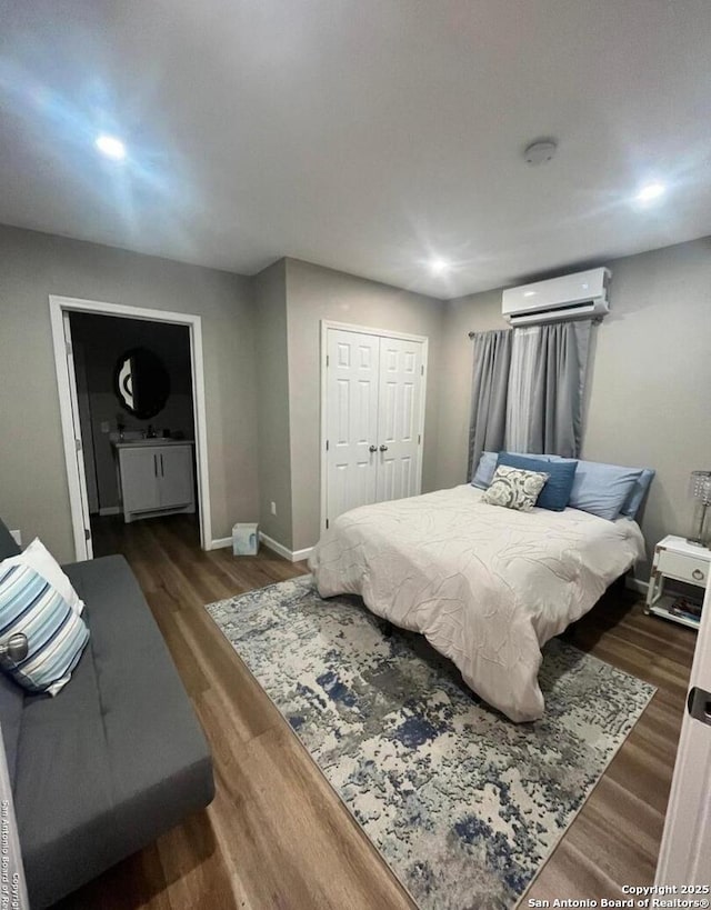 bedroom featuring dark hardwood / wood-style flooring, a wall unit AC, and a closet