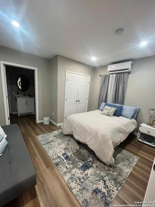 bedroom with dark hardwood / wood-style flooring, a closet, and an AC wall unit