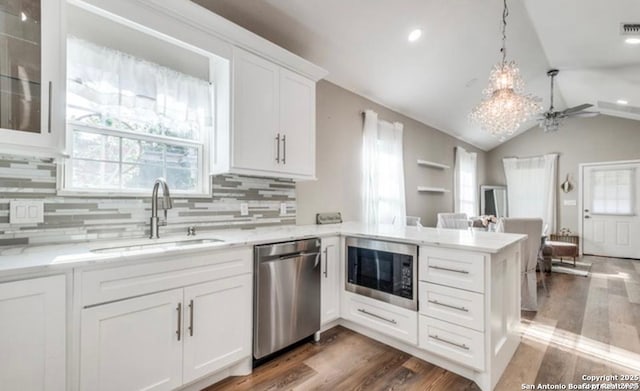 kitchen with sink, kitchen peninsula, white cabinets, and appliances with stainless steel finishes