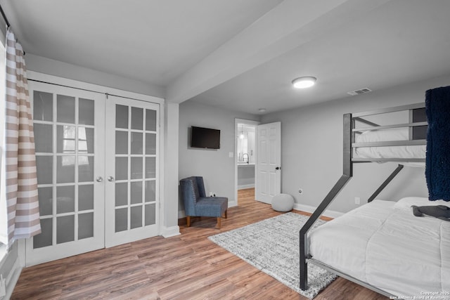 bedroom with french doors and hardwood / wood-style flooring