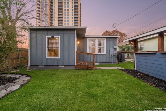 back house at dusk featuring a yard