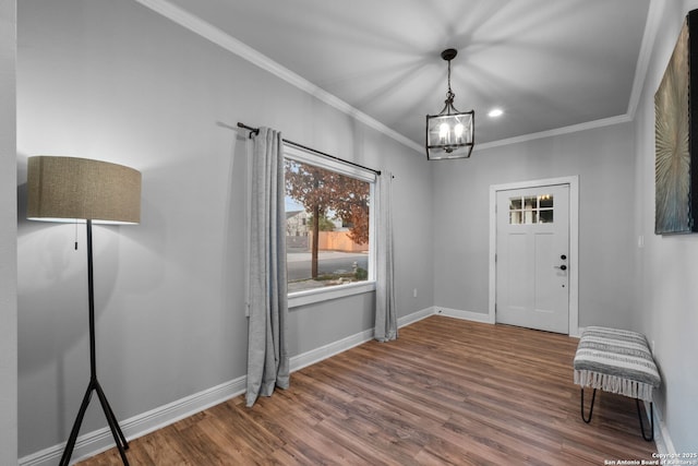 entrance foyer with crown molding, a chandelier, and dark hardwood / wood-style flooring