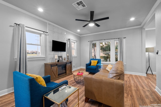 living room with hardwood / wood-style floors, crown molding, and ceiling fan