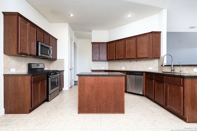 kitchen with tasteful backsplash, a center island, appliances with stainless steel finishes, and sink