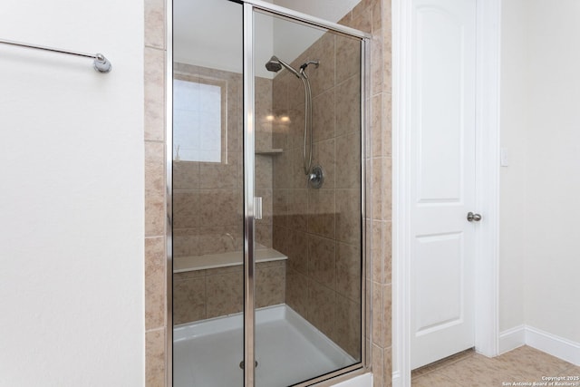 bathroom with an enclosed shower and tile patterned floors