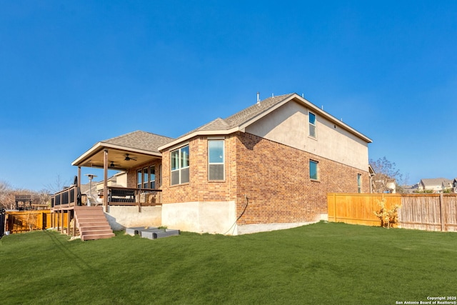 back of property featuring ceiling fan, a yard, and a deck