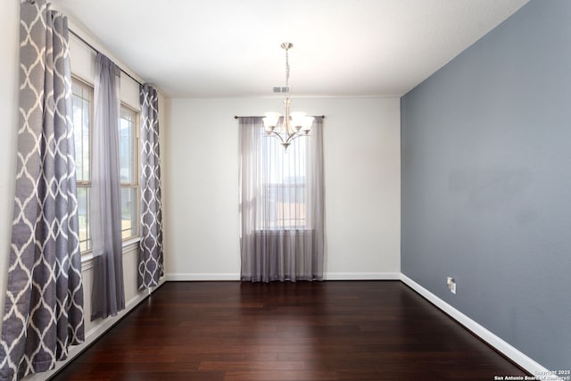 unfurnished room featuring dark hardwood / wood-style flooring and a chandelier