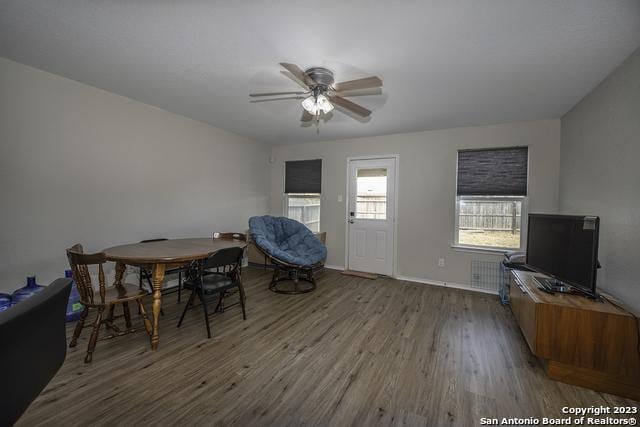 living area with ceiling fan and dark hardwood / wood-style flooring