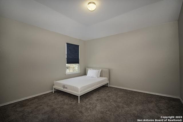 unfurnished bedroom with dark colored carpet