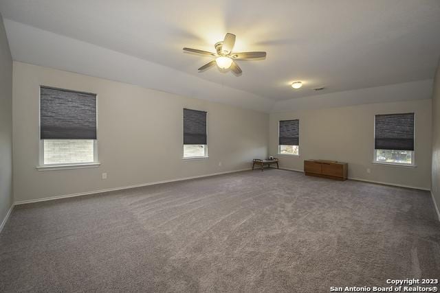 carpeted spare room featuring ceiling fan and a tray ceiling