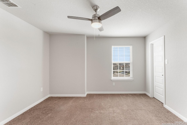 unfurnished room featuring light colored carpet, a textured ceiling, and ceiling fan