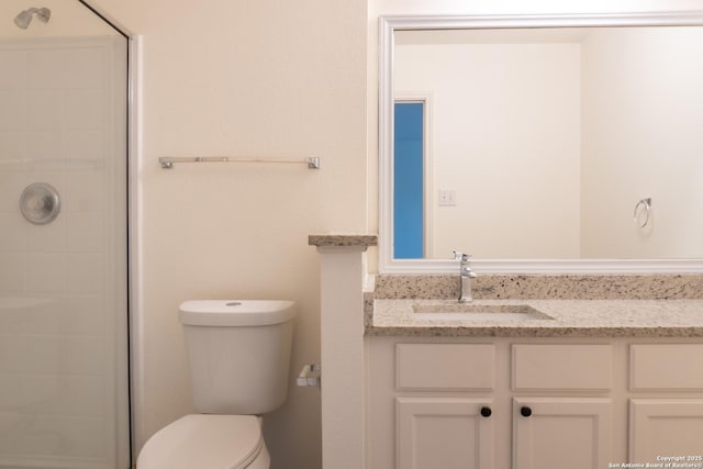 bathroom featuring vanity, walk in shower, and toilet