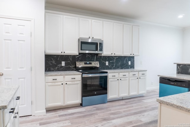 kitchen with ornamental molding, stainless steel appliances, light hardwood / wood-style flooring, and white cabinets