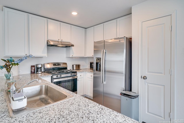 kitchen featuring white cabinetry, sink, light stone countertops, and appliances with stainless steel finishes