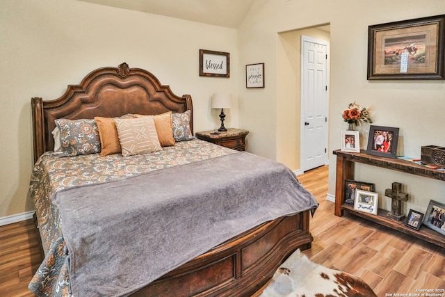 bedroom with lofted ceiling and light hardwood / wood-style flooring