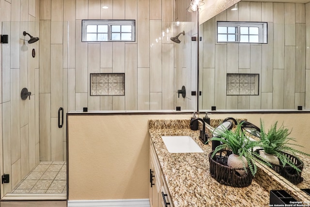 bathroom featuring a healthy amount of sunlight, vanity, and a shower with door